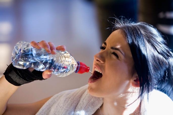 Devojka pije vodu iz flašice
