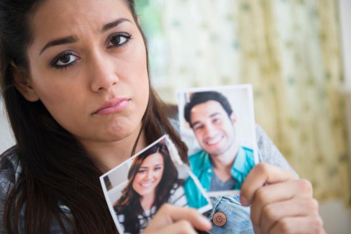 Devojka drži pocepanu fotografiju svog dečka