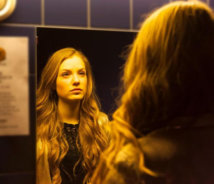 devojka se gleda u ogledalu