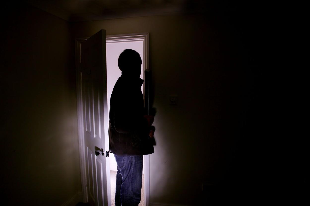 Čovek stoji pred vratima u mraku