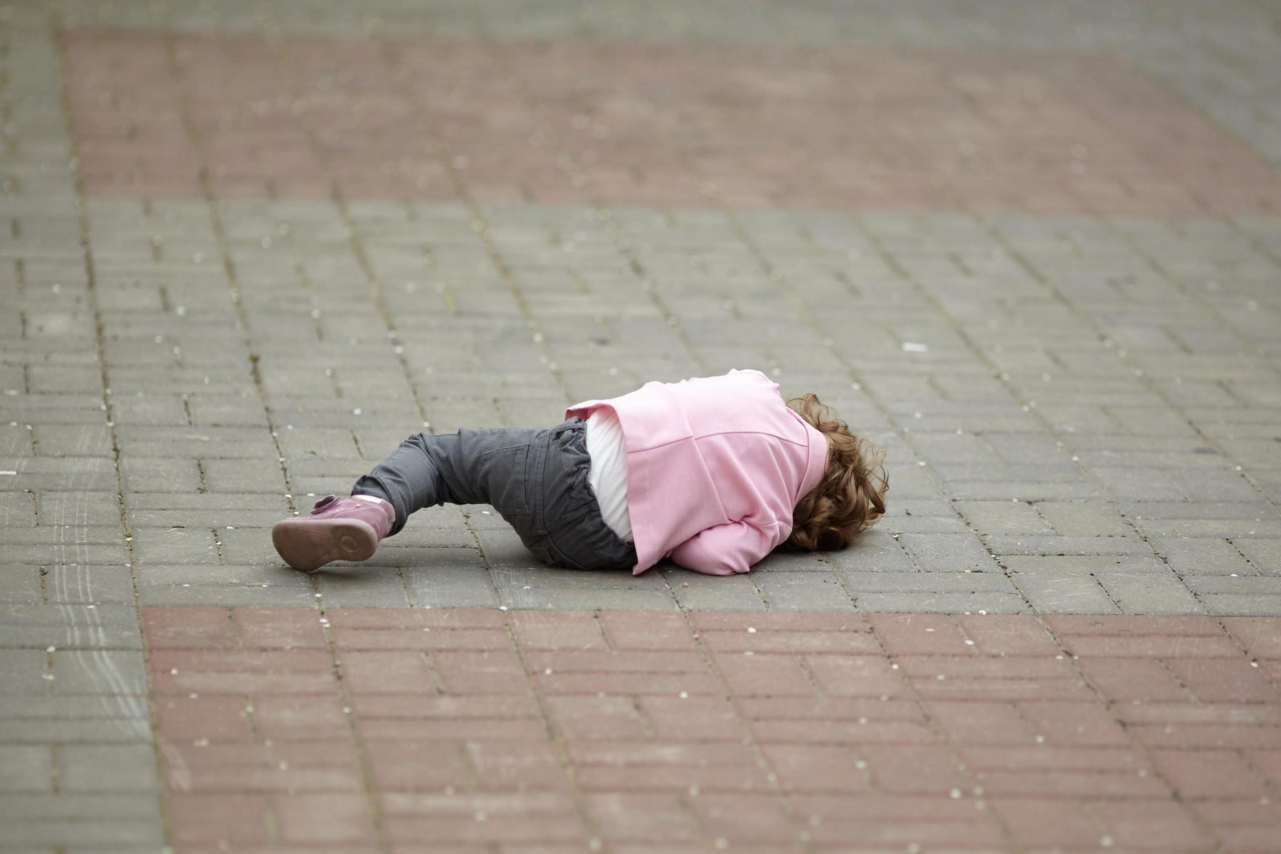devojčica leži na betonu